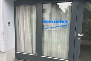 Eine Tür mit einer Milchglas-Verglasung und einem Schild mit der Aufschrift 'Seerauer DIE Ferienwohnung'.