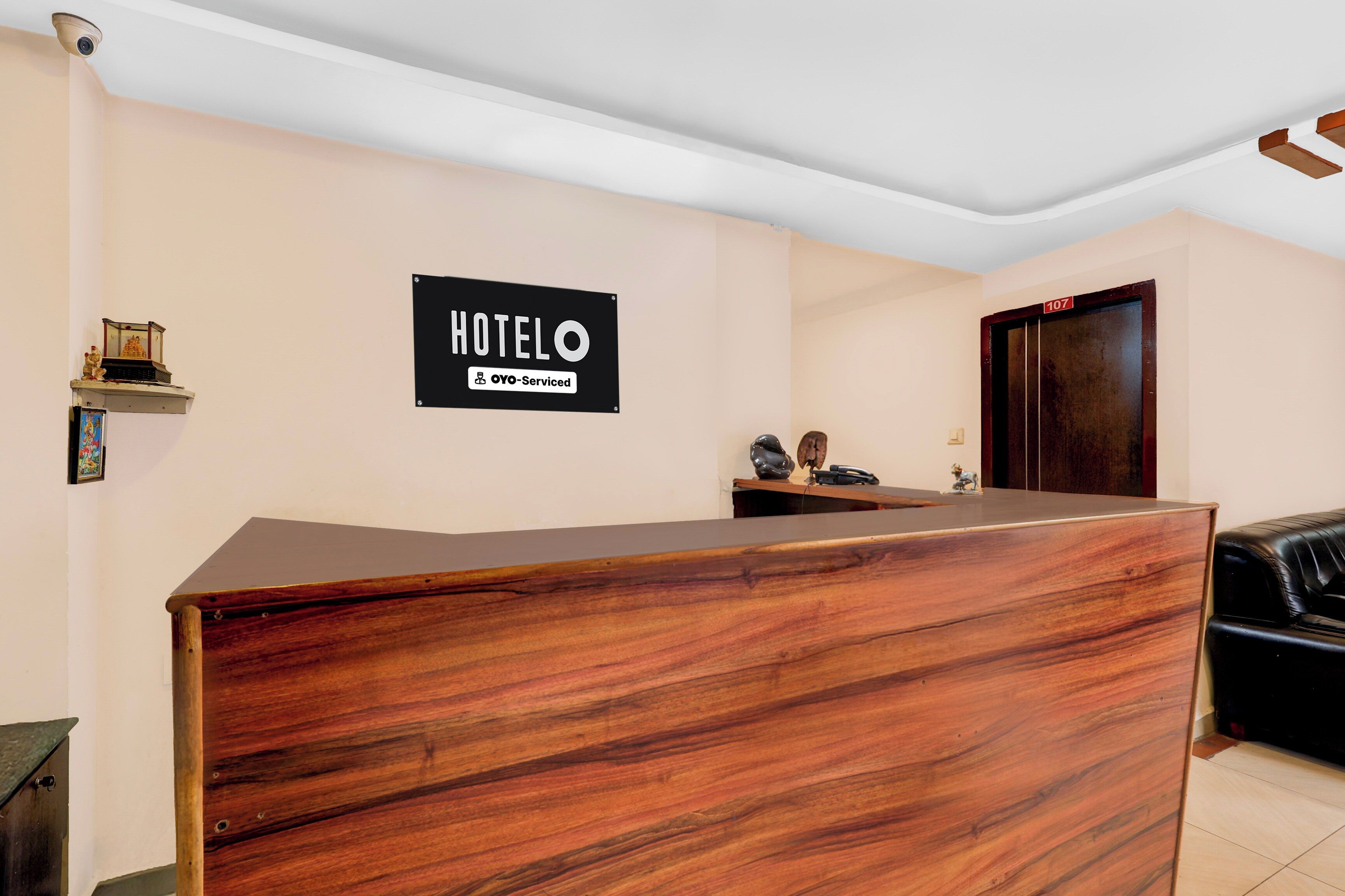 Bancada de recepção de hotel com uma placa indicando que o serviço é fornecido pela OYO.