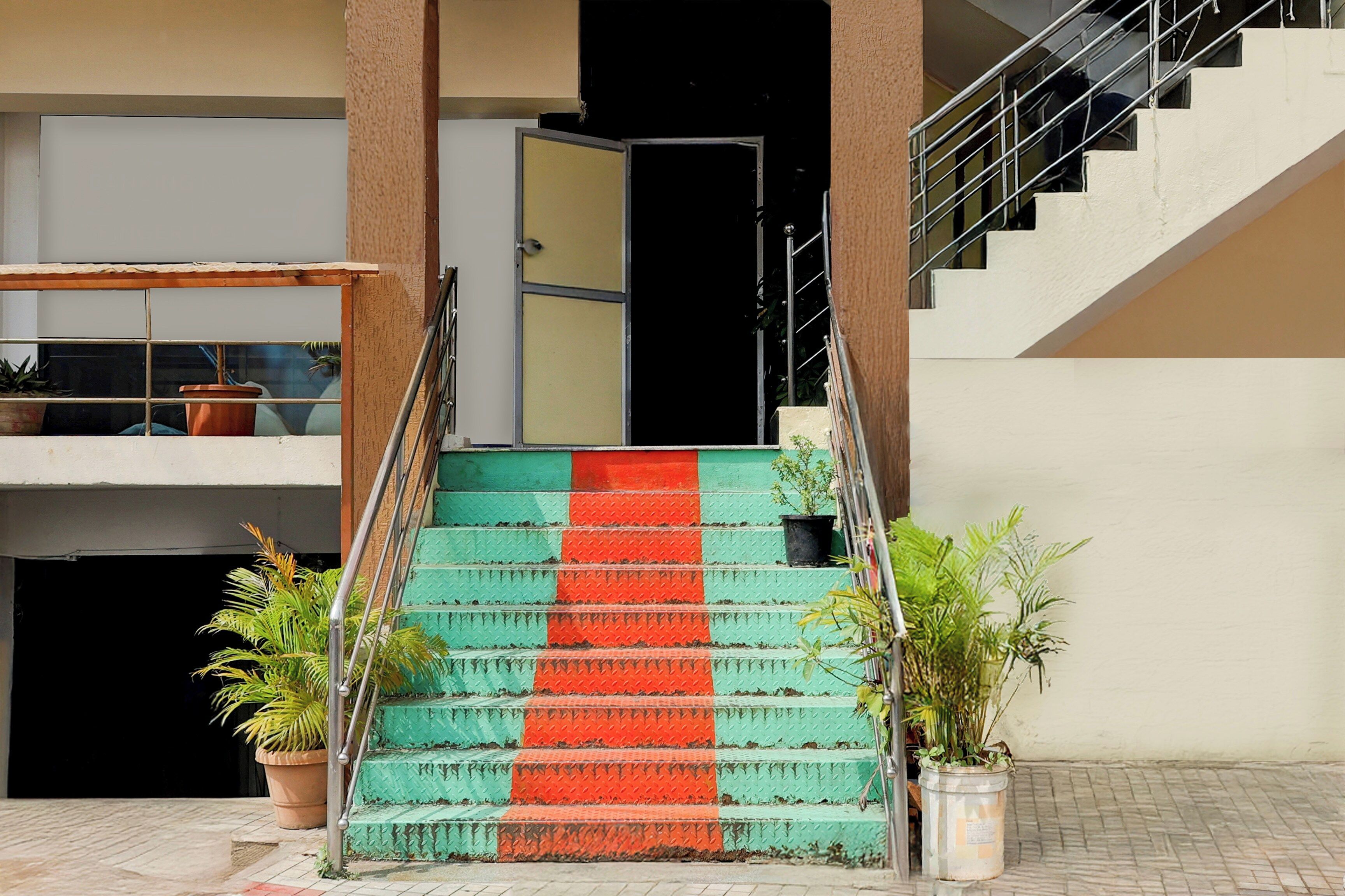 A staircase with alternating green and red steps leading to a building entrance.