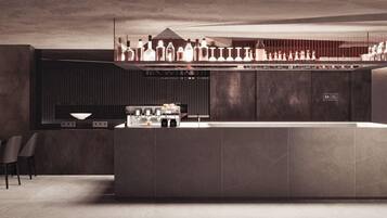 A modern bar area with a central island, seating, and a variety of bottles and glasses.