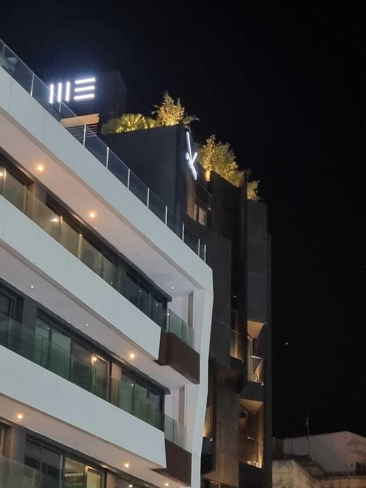 A multi-story building with illuminated signage and a modern architectural design.