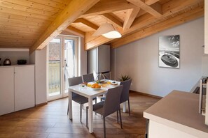 A modern kitchen with a dining table, chairs, and a hanging light fixture. - In the heart of the city, adjacent to the central Piazza del Popolo, at the gates of the historic center and close to the tree-lined avenue that leads to the sea, Il Maestrale is a delightful newly built attic, ready to accommodate up to 4 people.Withi (Albenga)