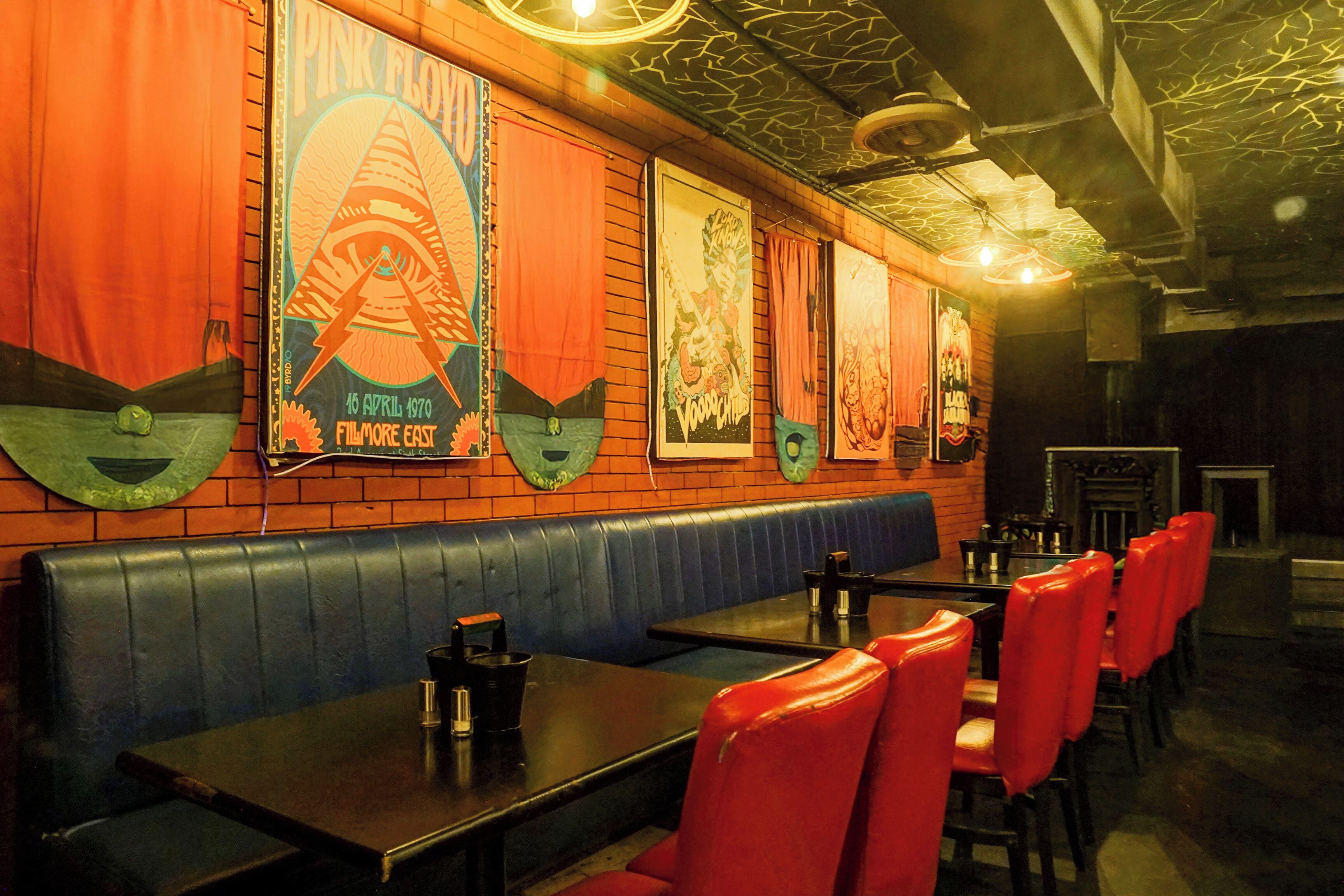A restaurant interior with booths, tables, and a brick wall.