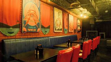 A restaurant interior with booths, tables, and a brick wall.