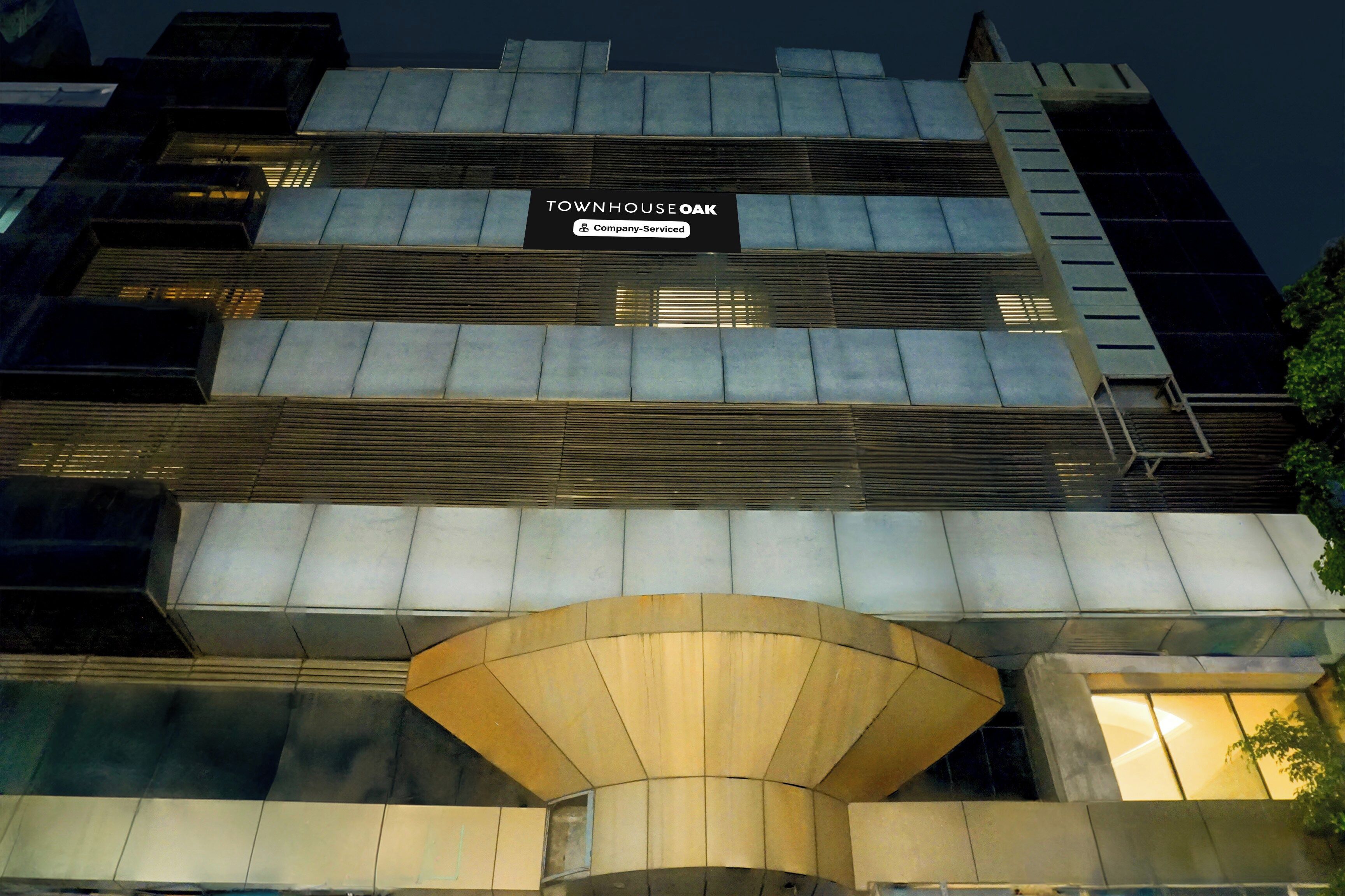 Un edificio moderno con un letrero que indica 'TOWNHOUSE OAK Company-Serviced'.