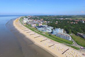 A coastal town with a beach, buildings, and a clear sky. - Strandpalais, Apt. 508 (Cuxhaven)