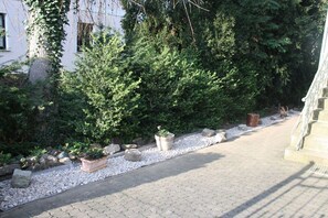 A pathway lined with potted plants and a stone structure. - Holiday apartment with 1 bedroom (Wernigerode)