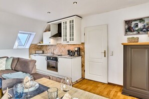 A compact kitchen with white cabinets, a built-in oven, and a coffee maker. - Holiday apartment with 3 bedrooms (Morsum)