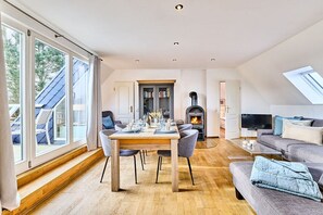 A spacious living area with a dining table, seating, a fireplace, and a television. - Holiday apartment with 3 bedrooms (Morsum)
