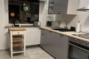 A kitchen with a wooden countertop, a microwave, a stove, and a sink. - Holiday home with 2 bedrooms (Nordstrand)