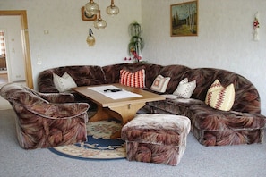 A room with a brown leather sofa set, a wooden coffee table, and a patterned rug. - Holiday apartment with 1 bedroom (Röslau)