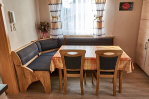 A cozy dining area with a wooden table, two chairs, and a bench. - Holiday apartment with 1 bedroom (Röslau)