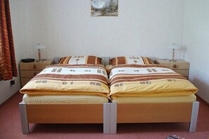 Un letto matrimoniale con copriletto a righe, due comodini con lampade e un quadro appeso al muro.