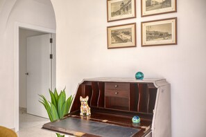 A room with a wooden bench, a small table with a decorative dog figurine, and a plant. There are framed pictures on the wall. - Spacious & bright apartment, sun terrace PGAL1-1 (Sliema)
