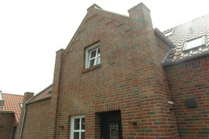 A brick building with a gabled roof and a small window. - Holiday apartment in Krummhörn with Wi-Fi (Krummhörn)