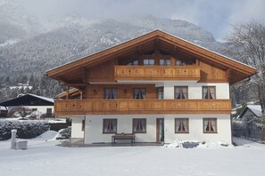 A multi-story wooden chalet with balconies, set against a snowy mountainous backdrop. - House at Kramer Holiday Apartment Kramer (Garmisch-Partenkirchen)