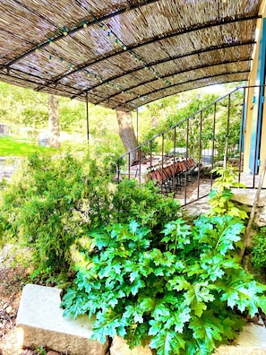 A covered outdoor area with a metal staircase leading to a seating area.