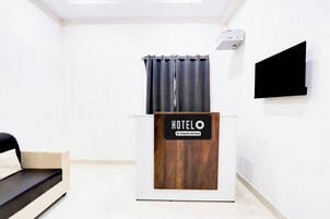 A hotel reception desk with a sign reading 'HOTELO Company Serviced.'