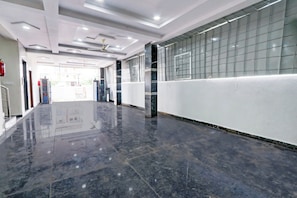 A corridor with a polished floor, white walls, and a glass block partition. - Super Hotel O Adibatla near TCS (Ibrahimpatan)