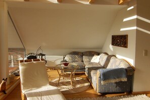 A cozy living room with a sofa, armchair, and a small table. - Holiday home with 2 bedrooms (Jemgum-Ditzum)