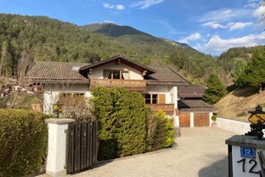 A two-story chalet with a balcony, surrounded by a mountain landscape. - Holiday apartment with 1 bedroom (Garmisch-Partenkirchen)