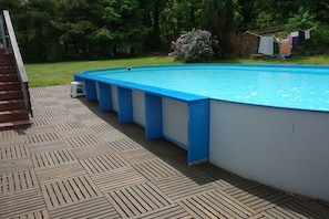 An outdoor swimming pool with a wooden deck and a clothesline with laundry. - Holiday apartment with 2 bedrooms (Ludwigswinkel)