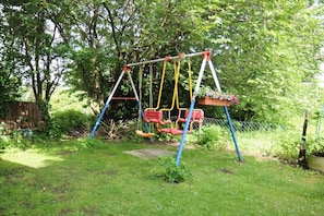 A swing set in a grassy area with trees in the background. - Holiday apartment in the Harz Mountains with 2 bedrooms (Bad Harzburg)