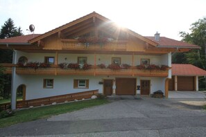 Ein zweistöckiges Haus mit Balkon, Garage und Auffahrt.