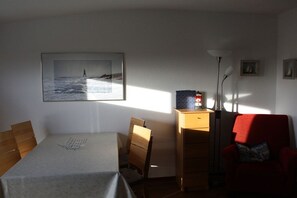 A room with a bed, a desk, a chair, a lamp, and a framed picture on the wall. - Holiday apartment with 2 bedrooms (Duhnen)
