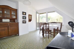 A dining area with a table and chairs, a wooden cabinet, and a view through a glass door. - Holiday home with 5 bedrooms (Wunstorf-Idensen)