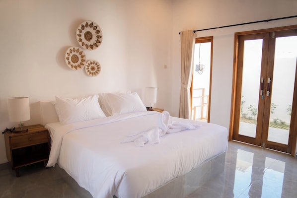 A hotel room with a bed, nightstands, a lamp, and a view through a sliding door.