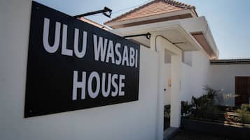 Un letrero que dice 'ULU WASABI HOUSE', mostrando claramente la entrada y un techo de tejas.