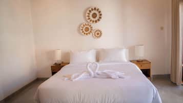 Habitación de hotel con una cama grande, dos mesitas de noche con lámparas y decoración en la pared.