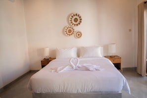 Habitación de hotel con una cama grande, dos mesitas de noche con lámparas y decoración en la pared.