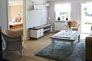 A room with a bed, a desk, a chair, a radiator, and a window with a view of the outside. - Holiday home in Uphusum with swimming pool (Uphusum)