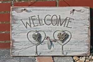 A rustic welcome sign with the word 'WELCOME' and two heart-shaped decorations. - Holiday home in Uphusum with swimming pool (Uphusum)