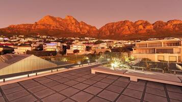 Une terrasse sur le toit offrant une vue sur la ville et les montagnes.