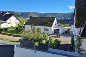 A residential area with houses, a clear sky, and a hilly landscape in the background. - Holiday apartment Mosselfischer (Mehring)