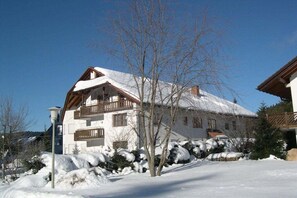 A two-story building with a snow-covered roof and a balcony. - House at Gutach No. 10 (Titisee-Neustadt)