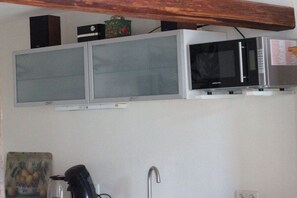 A kitchen with a microwave, a cabinet, and a sink. - Holiday apartment for families, room (Treis-Karden)