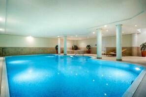 An indoor swimming pool with a clear water surface, surrounded by columns and potted plants. - Holiday apartment in Sylt with 3 bedrooms (Westerland)