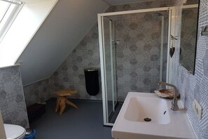 Ein Badezimmer mit Dusche, Waschbecken und Toilette.
