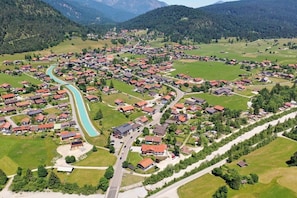 Luftaufnahme eines Dorfes mit Häusern, Straßen und einem Fluss.