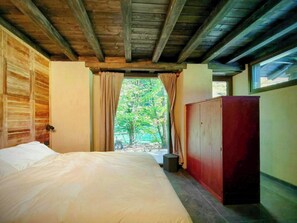 A bedroom with a bed, wooden walls, a wardrobe, and a window with curtains. - Mountain lodge in Val di Ledro with family history (Ledro)
