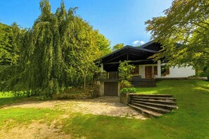 A house with a porch, a small garden, and a pathway leading to the entrance. - Mountain lodge in Val di Ledro with family history (Ledro)