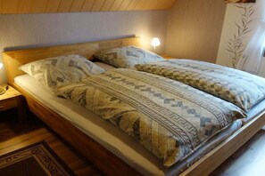 A bed with patterned bedding and a wooden headboard. - in Gretchen's house 2 (Südbrookmerland Ortsteil Moorhusen)