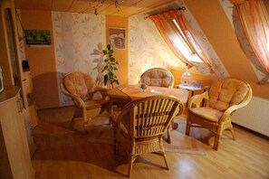 A dining area with wicker chairs, a table, and a plant. - in Gretchen's house 2 (Südbrookmerland Ortsteil Moorhusen)