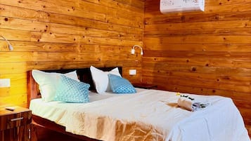 A wooden cabin room with a bed, nightstands, and a ceiling fan.