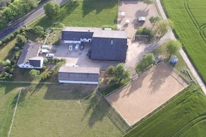 An aerial view of a property with a large building, a fenced area, and a parking lot. - Holiday home in Kail with swimming pool (Kail)