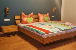 A bed with a checkered pillow, a quilt, and a bedside table. - Holiday home in Kail with swimming pool (Kail)